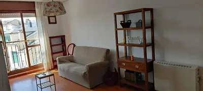 a living room with a chair and a book shelf at Apartamento Laguna in Ribadeo