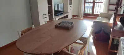 a wooden table in a living room with a television at Apartamento Laguna in Ribadeo