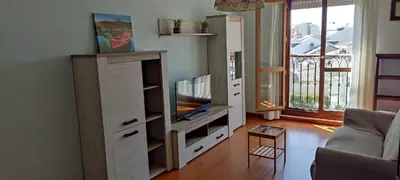 a living room with a entertainment center with a television at Apartamento Laguna in Ribadeo