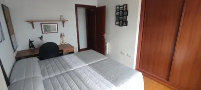 a bedroom with a bed and a desk and a wooden door at Apartamento Laguna in Ribadeo