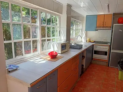 a kitchen with a counter and some windows at Molino cascada de caldas de reyes in Caldas de Reis