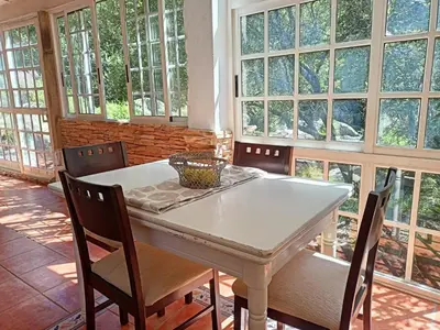 a dining room with a white table and chairs at Molino cascada de caldas de reyes in Caldas de Reis