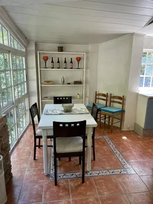 a dining room with a white table and chairs at Molino cascada de caldas de reyes in Caldas de Reis
