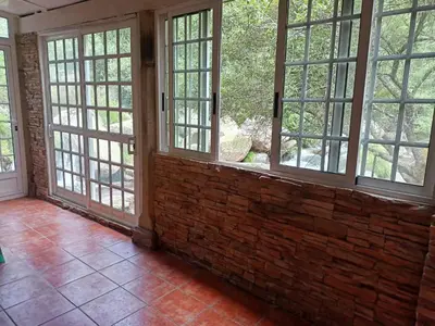 an empty room with windows and a brick wall at Molino cascada de caldas de reyes in Caldas de Reis