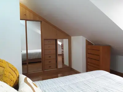 a bedroom with a bed and a dresser with a mirror at TEMPLE in Ponferrada