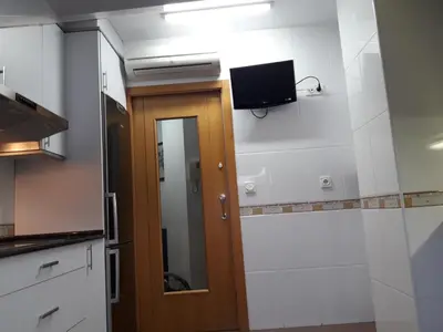 a kitchen with a door and a tv on the wall at TEMPLE in Ponferrada