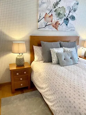 a bedroom with a bed and a lamp on a night stand at Andainas A in Milladoiro