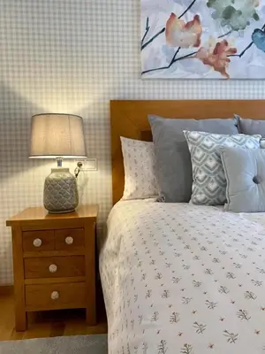 a bedroom with a bed and a table with a lamp at Andainas A in Milladoiro
