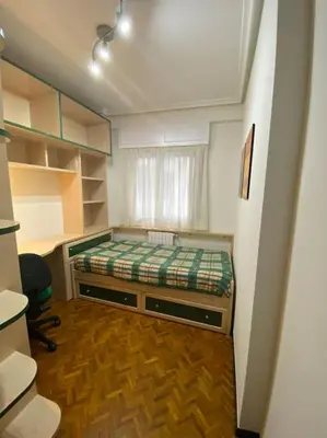 a small bedroom with a bed and a window at Piso Doniz in Ourense