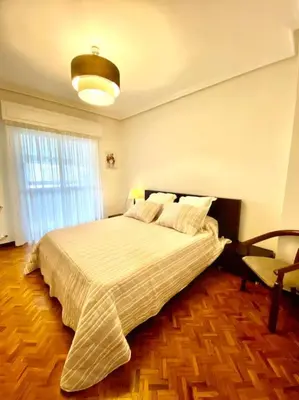 a bedroom with a large bed and a window at Piso Doniz in Ourense