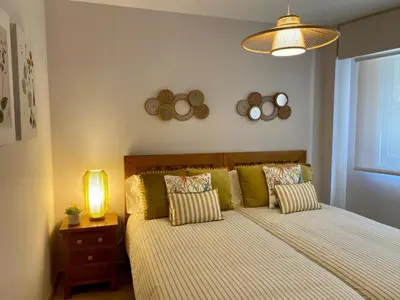 a bedroom with a bed with pillows and a lamp at Andainas B in Milladoiro