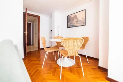 a dining room with wicker chairs and a table at Apartamento Carmiña in Puentedeume