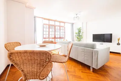 a living room with a couch and a table and chairs at Apartamento Carmiña in Puentedeume