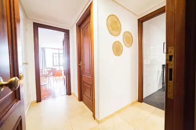 a hallway with a door and a room with a table at Apartamento Carmiña in Puentedeume