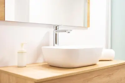 a white sink on a wooden counter in a bathroom at Apartamento Carmiña in Puentedeume