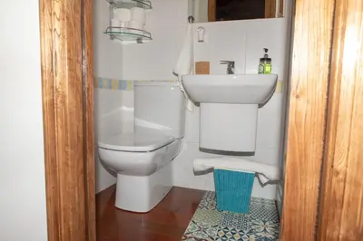 a bathroom with a white toilet and a sink at Casa do Cuco - Rural house in Friol