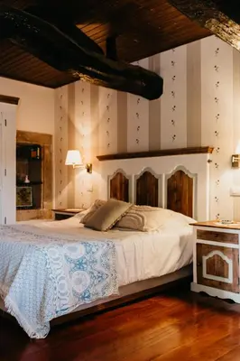 a bedroom with a large bed with a wooden headboard at Casa do Cuco - Rural house in Friol