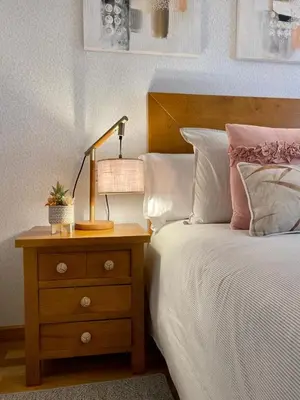 a bedroom with a bed and a nightstand with a lamp at Andainas F in Milladoiro