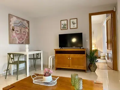 a living room with a flat screen tv and a table at Andainas F in Milladoiro