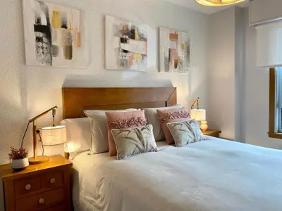 a bedroom with a large white bed with pillows at Andainas F in Milladoiro