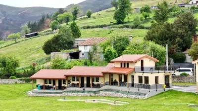 a house in a field with a hill in the background at Albergue Los Hospitales in Colinas de Arriba