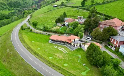 a house on a hill next to a road at Albergue Los Hospitales in Colinas de Arriba