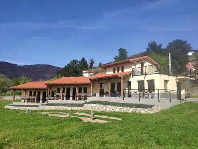 a house with a green field in front of it at Albergue Los Hospitales in Colinas de Arriba