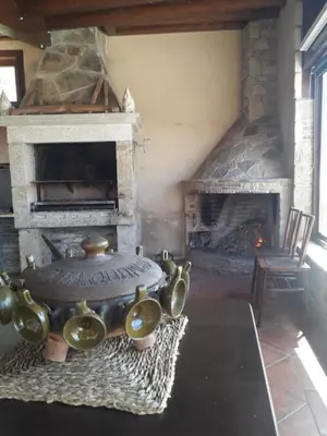 a stone fireplace with pots and pans in front of it at Casanova1914 in Villatuge