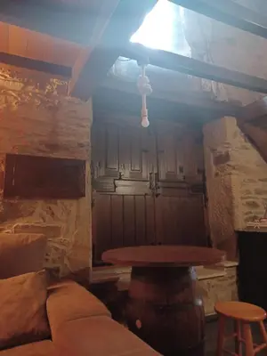a room with a table and a couch in a room with a stone wall at Casanova1914 in Villatuge
