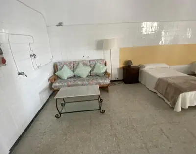 a small kitchen with a white table and green chairs at Bajo Loft con cocina y baño separados in Cillero