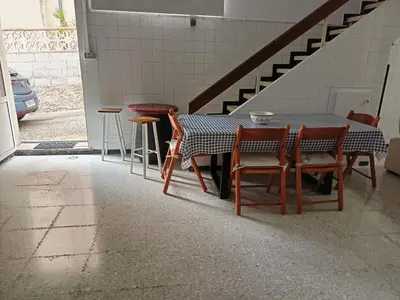 a table and chairs in a room with a staircase at Bajo Loft con cocina y baño separados in Cillero