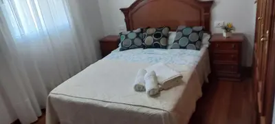 a bedroom with a bed with towels on it at Piso Villa Aurora in Carballino