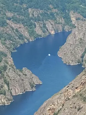 a boat in a river between two mountains at Piso Villa Aurora in Carballino