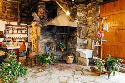 a kitchen with a stone fireplace and a sink at Agradable casa de aldea en un entorno natural in Layosa
