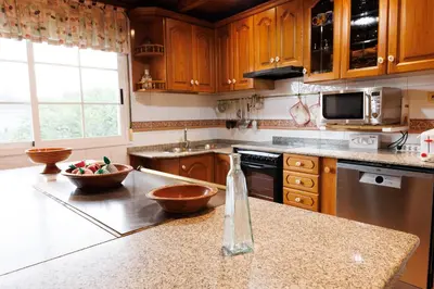 a kitchen with wooden cabinets and two bowls on a counter at Agradable casa de aldea en un entorno natural in Layosa
