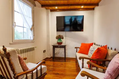 a living room with a couch and a tv at Agradable casa de aldea en un entorno natural in Layosa