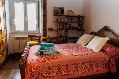 a bedroom with a bed with a red blanket and a window at Agradable casa de aldea en un entorno natural in Layosa