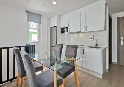 a dining room with a glass table and chairs at Playa de Foz Suites & Spa by gaiarooms in Foz