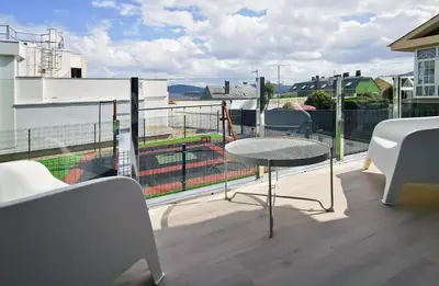 a balcony with a table and a view of a building at Playa de Foz Suites & Spa by gaiarooms in Foz