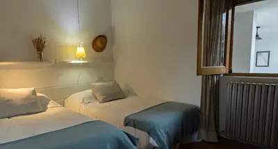 a room with two beds and a window at Casa Prada en Sanabria in Sotillo de Sanabria