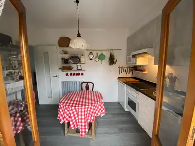 a kitchen with a table with a red and white table cloth at Casa Prada en Sanabria in Sotillo de Sanabria