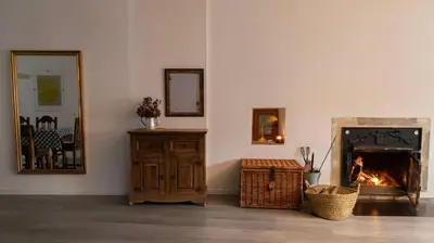 a living room with a fireplace and a mirror at Casa Prada en Sanabria in Sotillo de Sanabria