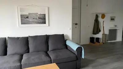 a living room with a gray couch and a picture on the wall at Casa Prada en Sanabria in Sotillo de Sanabria