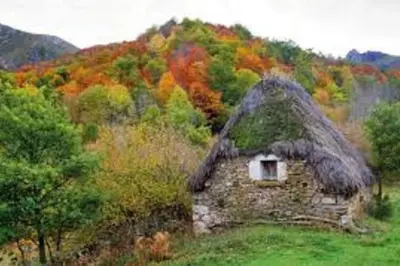 an old stone house with a grass roof in a field at zentralclub La Osera visionando la naturaleza in Santiago del Hermo