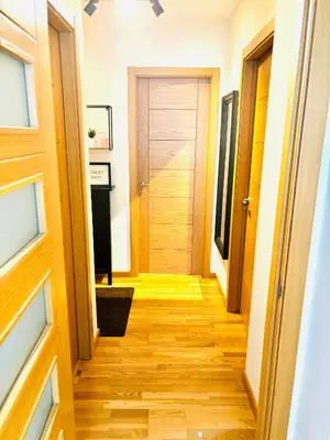 a hallway with a wooden floor and a door at Lula Apartamento in Betanzos