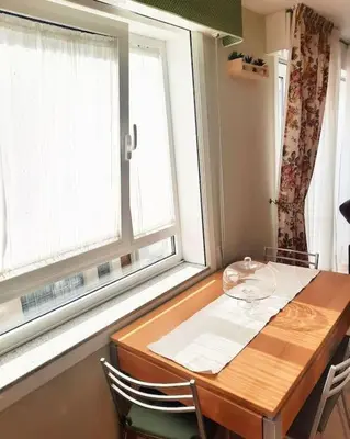 a dining room table with two chairs and a window at Lula Apartamento in Betanzos