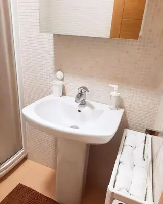 a bathroom with a white sink and a mirror at Lula Apartamento in Betanzos