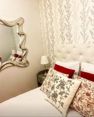 a bedroom with a bed with red pillows and a mirror at Lula Apartamento in Betanzos