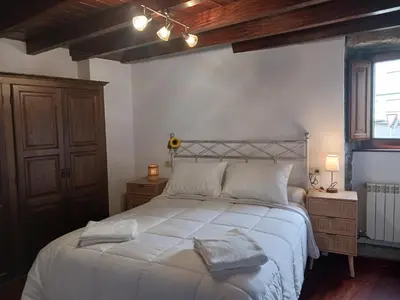a bedroom with a white bed and a wooden ceiling at Piedad Fernández Fernández Gestión de Inmuebles IV in Burela de Cabo