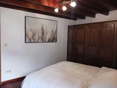 a bedroom with a bed and a mirror and a chair at Piedad Fernández Fernández Gestión de Inmuebles IV in Burela de Cabo
